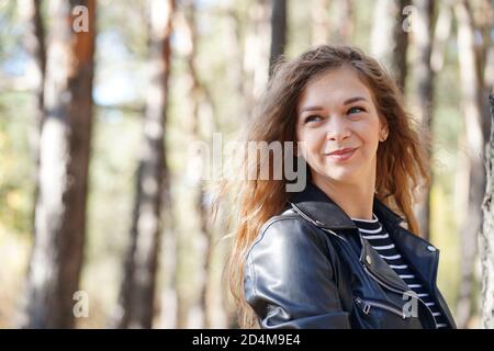 Nahaufnahme der attraktiven jungen Frau posiert in Holz. Charmante weibliche fotografiert vor der Kamera, im Wald stehend. Stockfoto