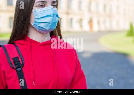 Abgeschnitten Nahaufnahme Foto von gesinnten nachdenklichen nachdenklichen Teenager-Mädchen Tragen Freizeitkleidung mit chirurgischen Maske draußen Stockfoto