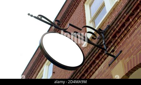 Leere Schild Poster an Backsteinwand, Blank runden Schild, Road Store Beratung machen Werbung alte Mode locken geschmiedete Schild Plakette. Stockfoto