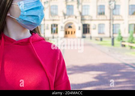 Cropped close up Foto Porträt von jungen Mädchen in lässig Roter Pullover trägt chirurgische Medizin Maske ins Krankenhaus gehen Stockfoto