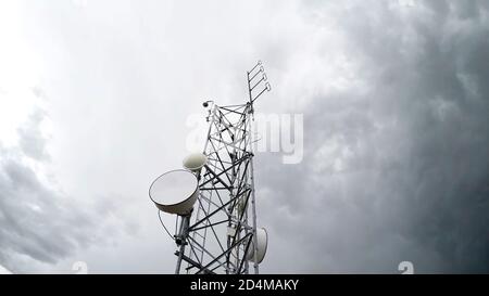 Funkantenne Tower Telekommunikation gegen wolkigen weißen Himmel in Low-Angle-Ansicht. Isolierter Hintergrund. Stockfoto