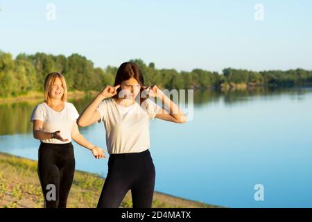 Zwei Freunde kämpfen, die Frau verschließt ihre Ohren, um keine Anschuldigungen und Spott zu hören. Der Begriff der Psychologie, Missverständnis Stockfoto