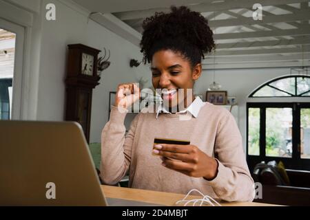 Junge Frau glücklich macht eine Online-Zahlung per Kreditkarte von zu Hause, Online-Shopping Stockfoto