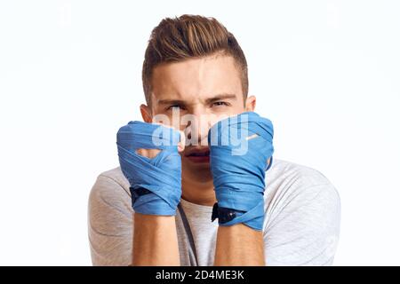 Sportliche Boxer in blauen Handschuhen üben Schläge auf ein Beschnittene Ansicht mit hellem Hintergrund Stockfoto