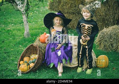 Frohe Halloween. Das Konzept der Kinderfreundschaft, Frieden, Freundlichkeit, Kindheit. Halloween Kinder genießen im Herbstpark auf Feld. Stockfoto