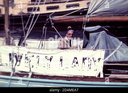 AJAXNETPHOTO. JULI 1968. SOUTHSEA, ENGLAND. - SEGLER KEHRT ZURÜCK - ALEC STAND AM STEUER SEINER 36 FUSS LANGEN KETCH LIVELY LADY AUF, ALS SIE AM ENDE SEINER SOLO-WELTREISE NACH PORTSMOUTH ZURÜCKKEHRTE. DER GEMÜSEHÄNDLER AUS SOUTHSEA SEGELTE AM 16. JULI 1967 AUS DER STADT. SEINE WAR DIE EINZIGE YACHT UNTER 40 FUSS, DIE MIT ZWEI STOPPS ODER WENIGER UM DIE WELT GESEGELT WAR UND DIE ZWEITE YACHT JEDER GRÖSSE, DIE DIE 28,000 MEILEN REISE ABSOLVIERT HAT. ROSE WAR AUCH DER ZWEITE LEBENSMITTELHÄNDLER IN DER GESCHICHTE, DER ZUM MITGLIED DES ROYAL YACHT SQUADRON GEWÄHLT WURDE (ZUERST SIR THOMAS LIPTON). FOTO: JONATHAN EASTLAND/AJAX REF:2120 Stockfoto