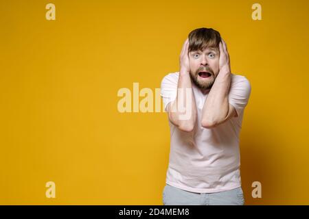 Schockierter bärtiger Mann bedeckte seine Ohren mit Händen, um den lauten Lärm der Nachbarn nicht zu hören. Speicherplatz kopieren. Stockfoto