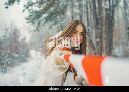 Schöne junge Frau, die draußen lacht. Wintersaison. Modell mit modischem Pullover und Handschuhen. Stockfoto