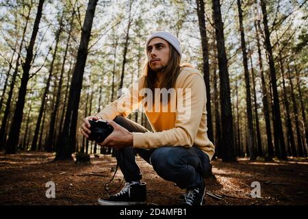 Hübscher junger kaukasischer männlicher Fotograf im Wald, der Fotos machte Und Hobby genießen Stockfoto