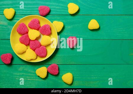 Bunte Marmelade. Gelbe und rote Marmelade in einer Untertasse auf einem grünen Holztisch. Blick von oben. Freier Platz Stockfoto