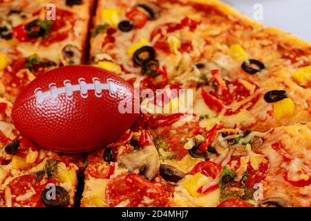 Pepperoni Supreme Pizza mit Fußball für american Football Party. Stockfoto