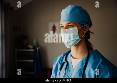 Nahaufnahme der jungen weiblichen kaukasischen Krankenschwester in Scrubs mit Medizinische Maske Stockfoto