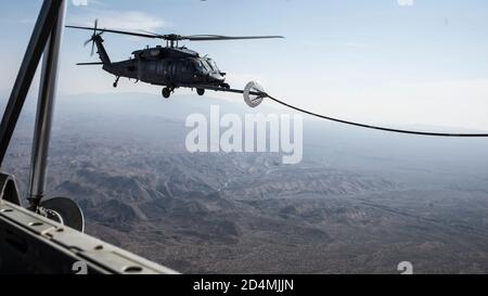 Ein U.S. Air Force HH-60G Pave Hawk erhält Treibstoff von einem HC-130J Combat King II über Arizona, 7. Oktober 2020. Diese Luft-Luft-Auftanken-Mission war Teil der fortlaufenden Schulungen der 563d Rescue Group, um die Interoperabilität zwischen den verschiedenen Staffeln und Einsatzgruppen zu gewährleisten. (USA Luftwaffe Foto von Senior Airman Jacob T. Stephens) Stockfoto