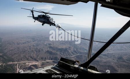 Ein U.S. Air Force HH-60G Pave Hawk erhält Treibstoff von einem HC-130J Combat King II über Arizona, 7. Oktober 2020. Diese Luft-Luft-Auftanken-Mission war Teil der fortlaufenden Schulungen der 563d Rescue Group, um die Interoperabilität zwischen den verschiedenen Staffeln und Einsatzgruppen zu gewährleisten. (USA Luftwaffe Foto von Senior Airman Jacob T. Stephens) Stockfoto