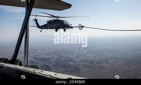 Ein U.S. Air Force HH-60G Pave Hawk erhält Treibstoff von einem HC-130J Combat King II über Arizona, 7. Oktober 2020. Diese Luft-Luft-Auftanken-Mission war Teil der fortlaufenden Schulungen der 563d Rescue Group, um die Interoperabilität zwischen den verschiedenen Staffeln und Einsatzgruppen zu gewährleisten. (USA Luftwaffe Foto von Senior Airman Jacob T. Stephens) Stockfoto