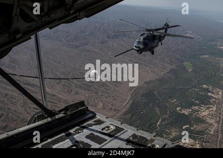 Ein U.S. Air Force HH-60G Pave Hawk erhält Treibstoff von einem HC-130J Combat King II über Arizona, 7. Oktober 2020. Diese Luft-Luft-Auftanken-Mission war Teil der fortlaufenden Schulungen der 563d Rescue Group, um die Interoperabilität zwischen den verschiedenen Staffeln und Einsatzgruppen zu gewährleisten. (USA Luftwaffe Foto von Senior Airman Jacob T. Stephens) Stockfoto