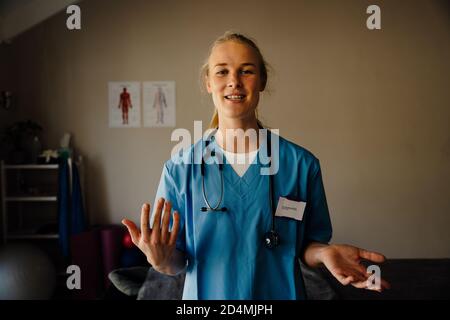 Schöne Ärztin in Scrubs geben medizinische Beratung auf Videoanruf, Diskussionskonzept Stockfoto