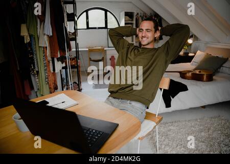 Glücklich und entspannt kaukasischen männlichen Arbeit im Schlafzimmer zu Hause, beendete Arbeit und abgeschlossen erfolgreichen Geschäftsabschluss Stockfoto