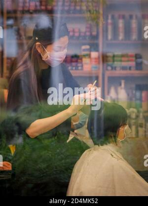 Vancouver, Kanada. Oktober 2020. Ein Friseur trägt eine Gesichtsmaske gibt einen Haarschnitt an einen Kunden in Vancouver, British Columbia, Kanada, 9. Oktober 2020. Laut einem neuen COVID-19 Modellierungsbericht der kanadischen Regierung am Freitag. Die Gesamtzahl der kanadischen COVID-19 ist auf dem Weg, zwischen 188,150 und 197,830 Fälle und zwischen 9,690 und 9,800 Todesfälle ab Oktober 17 zu treffen. Am Freitagmittag gab es laut CTV insgesamt 177,613 COVID-19 Fälle und 9,583 Todesfälle. Quelle: Liang Sen/Xinhua/Alamy Live News Stockfoto