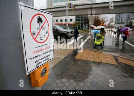 Vancouver, Kanada. Oktober 2020. Ein Schild, das die Leute auffordert, die Ampeltaste nicht zu berühren, um die Ausbreitung von COVID-19 zu begrenzen, ist auf einer Straße in Vancouver, British Columbia, Kanada, 9. Oktober 2020 zu sehen. Laut einem neuen COVID-19 Modellierungsbericht der kanadischen Regierung am Freitag. Die Gesamtzahl der kanadischen COVID-19 ist auf dem Weg, zwischen 188,150 und 197,830 Fälle und zwischen 9,690 und 9,800 Todesfälle ab Oktober 17 zu treffen. Am Freitagmittag gab es laut CTV insgesamt 177,613 COVID-19 Fälle und 9,583 Todesfälle. Quelle: Liang Sen/Xinhua/Alamy Live News Stockfoto