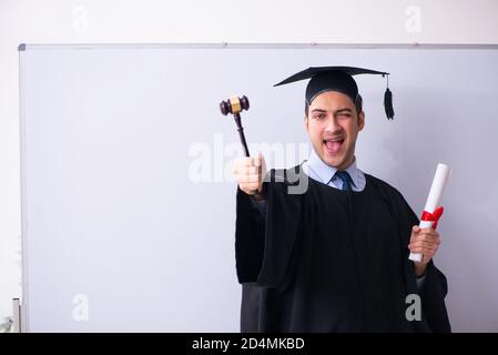 Junger männlicher Absolvent vor dem Vorstand Stockfoto