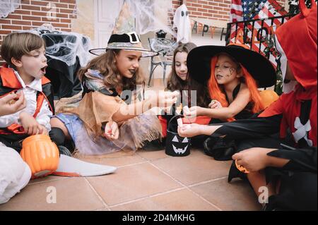 Kinder teilen und vergleichen ihre Süßigkeiten an halloween Stockfoto