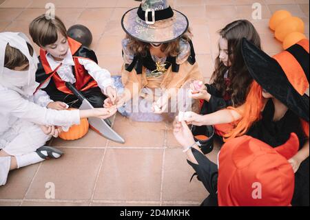 Kinder teilen und vergleichen ihre Süßigkeiten an halloween Stockfoto