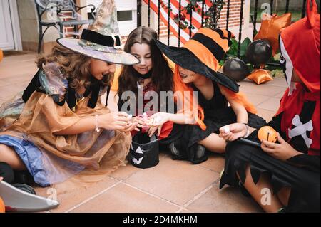 Kinder teilen und vergleichen ihre Süßigkeiten an halloween Stockfoto