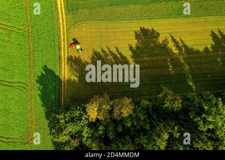 Luftaufnahme des Bauernhofes mit Traktor im Abendlicht stehen. Stockfoto