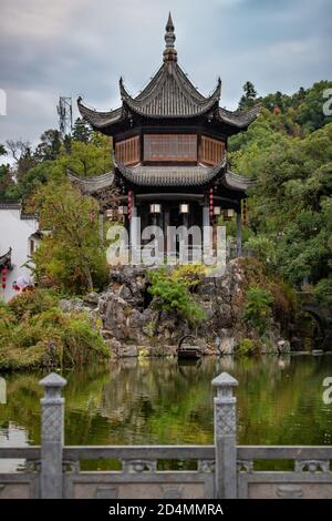 Vertikale Aufnahme eines japanischen Tempels umgeben von Pflanzen und Ein See Stockfoto