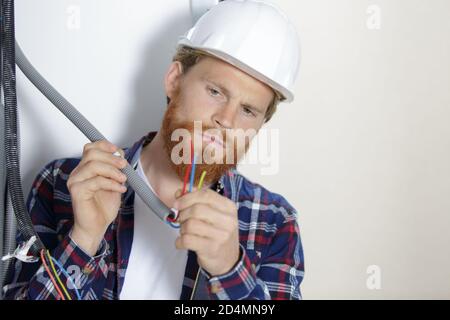 Der Techniker hält verschiedene Kabel in der Hand Stockfoto