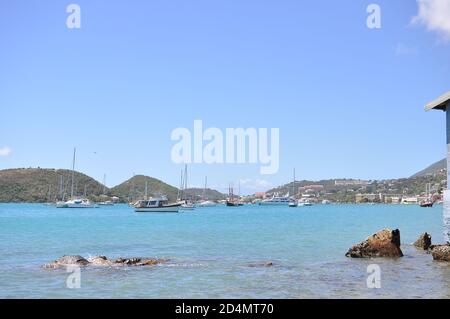 Wasserhafen von Charlotte Amalie mit Booten und Yachten auf dem Wasser und Hügeln im Hintergrund verankert. Stockfoto