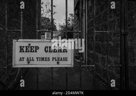 Halten Sie sich immer frei, bitte am Metalleingangszaun Blockiert Stockfoto