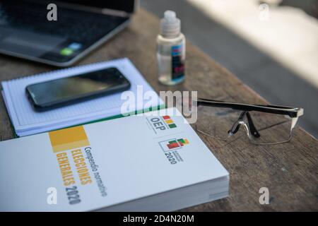 La Paz, Bolivien. Oktober 2020. Ein Buch mit den Wahlbestimmungen liegt auf dem Tisch eines Beamten neben seiner Schutzbrille und einer Flasche Handdesinfektionsmittel. Die Wahl soll am 18. Oktober 2020 stattfinden, fast genau ein Jahr nach der letzten umstrittenen, die zu einer schweren politischen Krise in Bolivien und zum erzwungenen Rücktritt des ehemaligen Präsidenten Evo Morales geführt hat. Kredit: Radoslaw Czajkowski/ Alamy Live Nachrichten Stockfoto