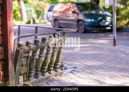 Alte Steinbalustraden auf den Straßen der Stadt sind schief. Der baufällige Zaun ist renovierungsbedürftig. Stockfoto