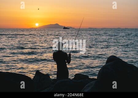 Fischer oder Angler an der Sorrentine Coast oder Peninsula in Der Sonnenuntergang gegenüber von Ischia bei Dämmerung Stockfoto