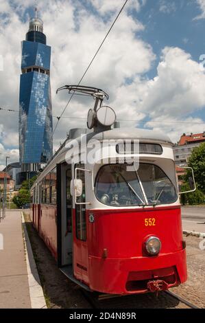 Sarajevo, Bosnien und Herzegowina. Juli 2019. Eine alte Straßenbahn wartet an einer Straßenbahnhaltestelle mit dem Avaz Twist Tower im Hintergrund. Kredit: John Wreford/SOPA Images/ZUMA Wire/Alamy Live Nachrichten Stockfoto