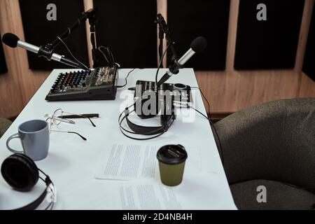 Arbeitsplatz des Radiohosts. Nahaufnahme von Mikrofonen, Kopfhörern, Tonmischpult, Drehbuch auf dem Tisch im Aufnahmestudio oder Rundfunkraum Stockfoto