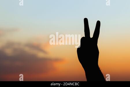 Hand des Menschen isoliert auf Himmel Hintergrund - Frieden Geste Silhouette Stockfoto