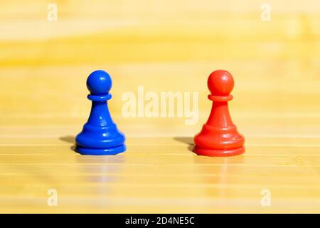 Rote und blaue Schachfiguren, rote Pille und blaue Pille Wahl Konzept, Paar von einfachen verschiedenen gegensätzlichen mehrfarbigen Spielfiguren zu wählen, Nahaufnahme Stockfoto