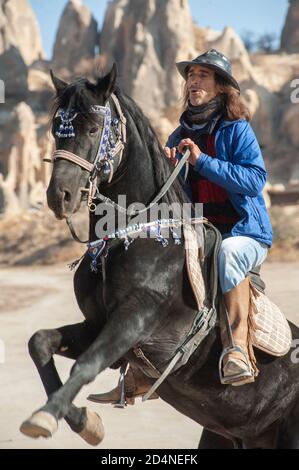 Kappadokien, Türkei. 8. November 2017 Ekram Besitzer der Dalton Brothers Ranch zu seiner Freude und seinem Stolz hält er einen schwarz-kohlegarenen Hengst in einer Höhle Stockfoto