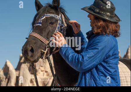 Kappadokien, Türkei. 8. November 2017 Ekram Besitzer der Dalton Brothers Ranch zu seiner Freude und seinem Stolz hält er einen schwarz-kohlegarenen Hengst in einer Höhle Stockfoto