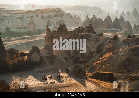 Kappadokien, Türkei. 8. November 2017 Reiter fahren durch die vulkanische Landschaft des anatolischen Kappadokiens, bekannt als das Land der schönen Pferde. Stockfoto