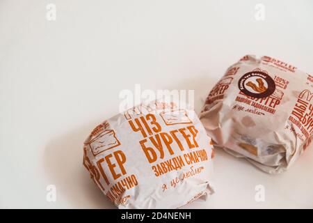 Lviv / Ukraine - April 2020: Zwei Cheeseburger von ukrainischen McDonalds auf einem weißen Tisch zu Hause. Ungesunde Ernährung während des Coronavirus-Ausbruchs. Auftrag Stockfoto