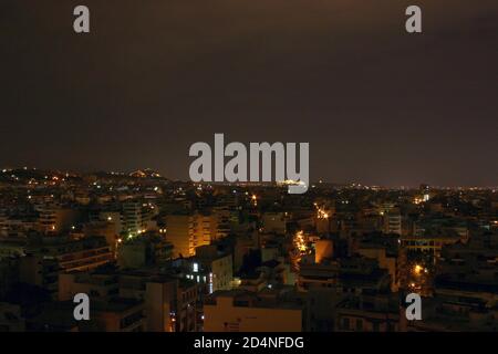 Panoramablick auf die Stadt Athen bei Nacht, mit der Akropolis und dem Parthenon im Hintergrund, aufgenommen von Ano Patisia. Stockfoto