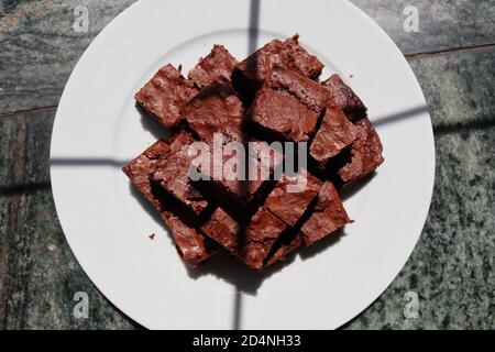 Top-Down Brownies mit Sonnenschein drauf mit ein paar Window Shadows. Blick von oben auf hausgemachten glutenfreien Brownie. Stockfoto