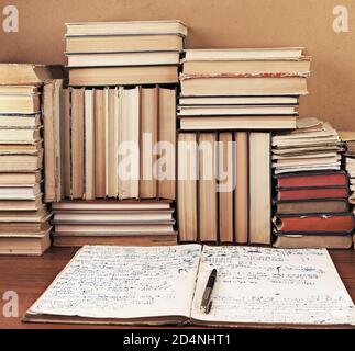 Schreiben-Buch mit mathematischen Vorlesungen vor einem Hintergrund eine Menge Bücher Stockfoto