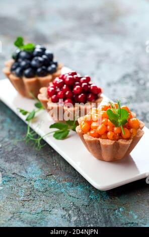 Gesunde Kokosnusstartlets mit Pudding und frischen Beeren, selektiver Fokus Stockfoto