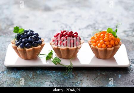 Gesunde Kokosnusstartlets mit Pudding und frischen Beeren, selektiver Fokus Stockfoto