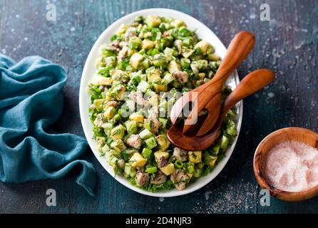 Salat mit Avocado, Gurken, Sardinen und Kräutern aus der Dose, selektiver Fokus Stockfoto